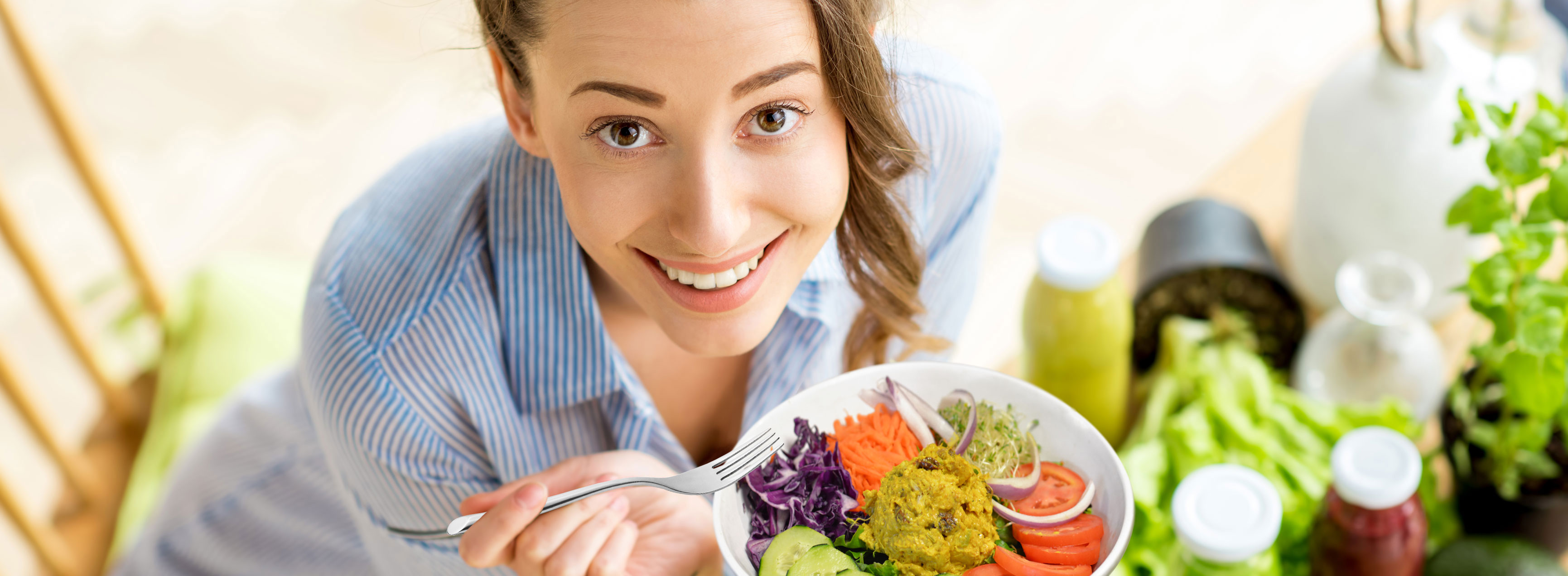 picture of woman eating our famous greens and tuna walnut salad